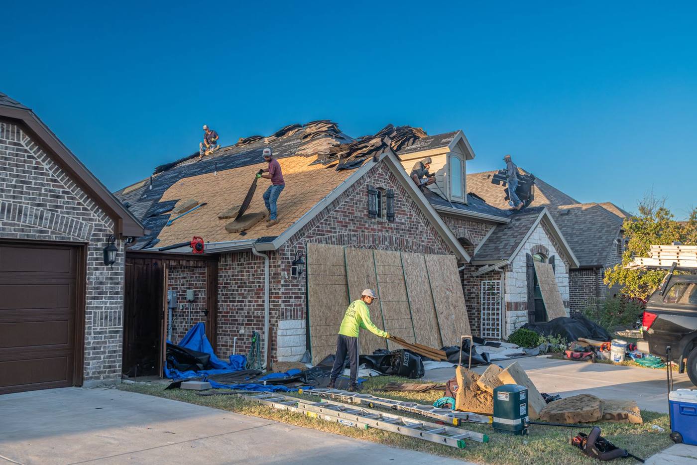 Crew replacing a roof on a brick house